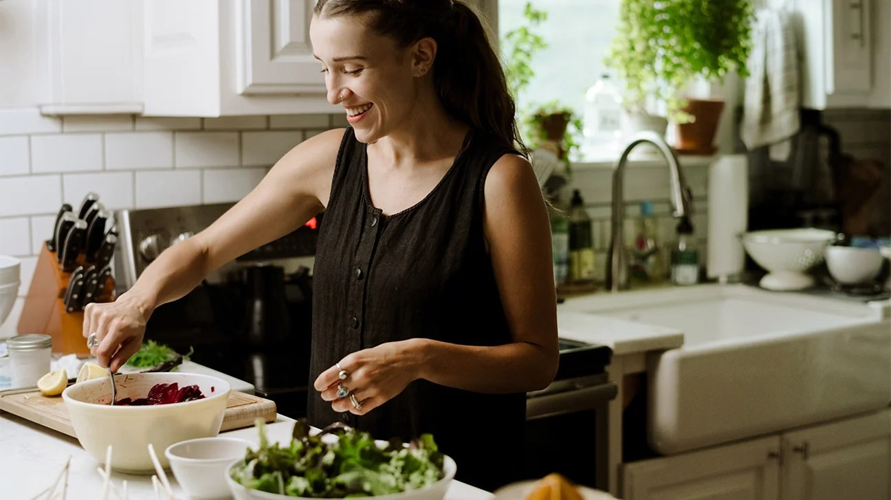 Người phụ nữ chuẩn bị salad trong bếp